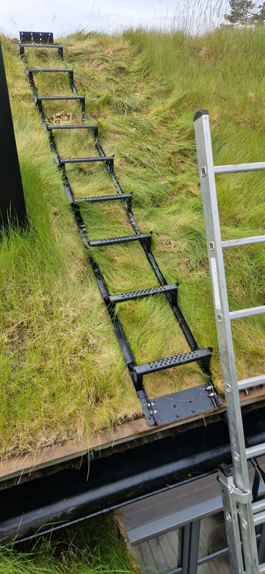 Montør monterer takstige på skrått tak